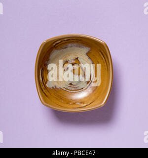 Vintage brown dish isolated on purple background Stock Photo