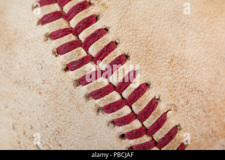 Close up macro view of red stitched seams of an worn baseball. Stock Photo