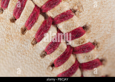 Close up macro view of red stitched seams of an worn baseball. Stock Photo