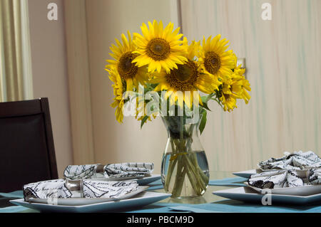 The beautiful centerpiece filled with sunflowers on a dining room table Stock Photo