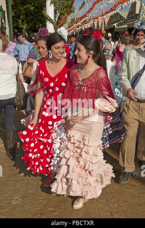 April Fair, Young women wearing a traditional flamenco dress, Seville, Region of Andalusia, Spain, Europe. Stock Photo