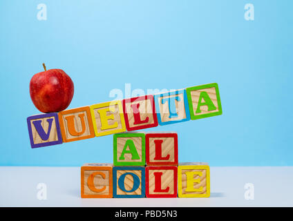 Back to School spelled out in spanish with wooden blocks with apple Stock Photo