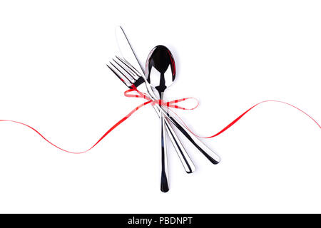 Fork, spoon and knife tied with red ribbon. Isolated on white. Stock Photo