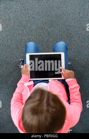 Girl 9 10 11 on an ipad with a blank screen copy space elementary school age Stock Photo