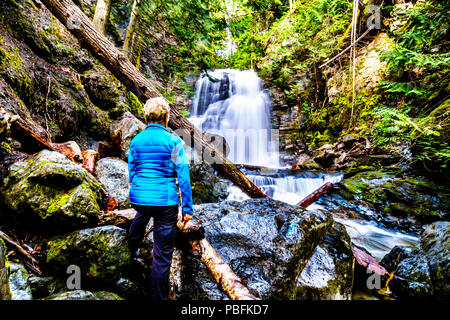 Senior Woman at Whitecroft Falls, a waterfall on McGillivray Creek and a short hike from Sun Peaks Road near the town of Whitecroft in BC, Canada Stock Photo