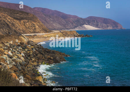 Iconic View of Pacific Coast Highway winding along the Southern California coast with the Santa Monica Mountains on one side of the road and Pacific O Stock Photo
