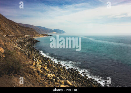 Iconic View of Pacific Coast Highway winding along the Southern California coast with the Santa Monica Mountains on one side of the road and Pacific O Stock Photo