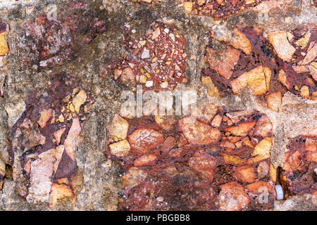 Cemented naural flint rough dirty red stone wall background Stock Photo