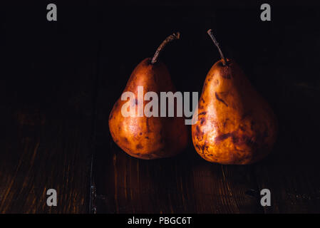 Two Golden Pears on Dark Wooden Table Stock Photo