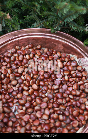 Copper pan of roasting chestnuts at a Christmas Market Stock Photo