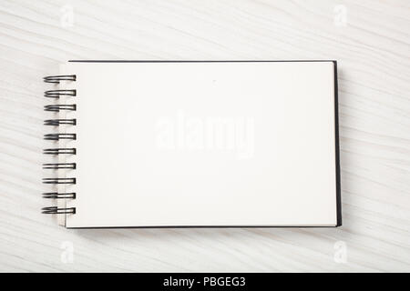 Open notebook, isolated on white wooden background, copy space, top view	 Stock Photo
