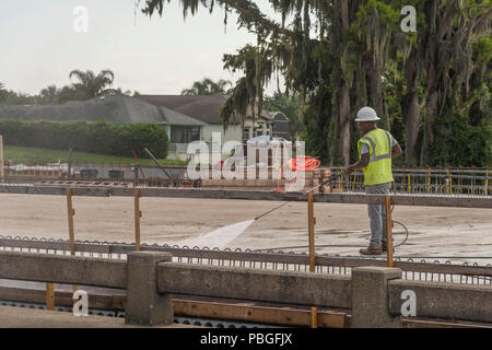 Black man pressure washing a concrete road base in Lake County, Florida Stock Photo