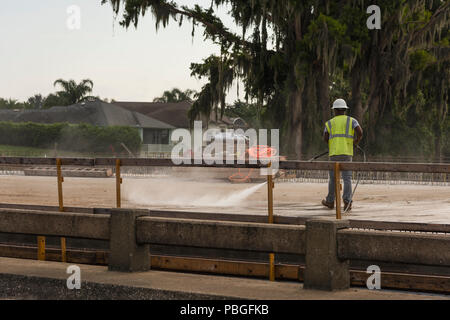 Black man pressure washing a concrete road base in Lake County, Florida Stock Photo