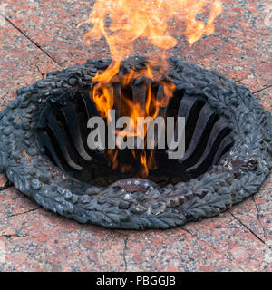 Eternal flame in a metal frame on a stone slab Stock Photo