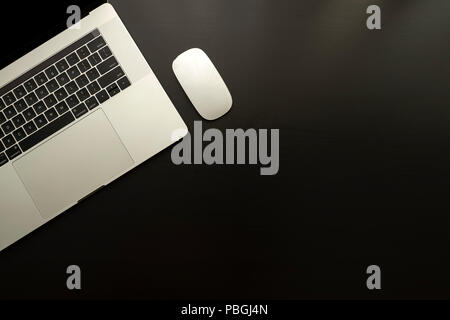 laptop and mouse over black wooden table monochromatic flat lay composition Stock Photo