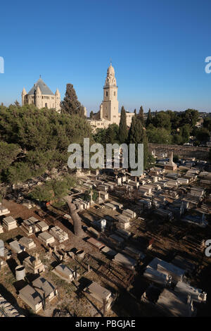 View of the Conical dome and bell tower of the Church of the Benedictine Abbey of the Dormition across the Protestant Mount Zion Cemetery established by Presbyterian missionaries in the 19th-century located on the southwestern slope of Mount Zion in Jerusalem Israel Stock Photo