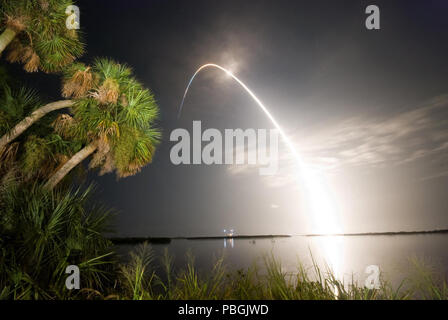 Viewed from the Banana River Viewing Site at NASA's Kennedy Space Center in Florida, Space Shuttle Discovery arcs through a cloud-brushed sky, lighted by the trail of fire after launch on the STS-128 mission. Stock Photo