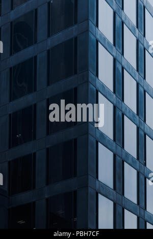 Square office windows in the building corner with light shade Stock Photo