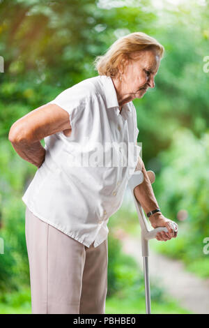 Old woman with lumbago pain while walking in the nature Stock Photo - Alamy