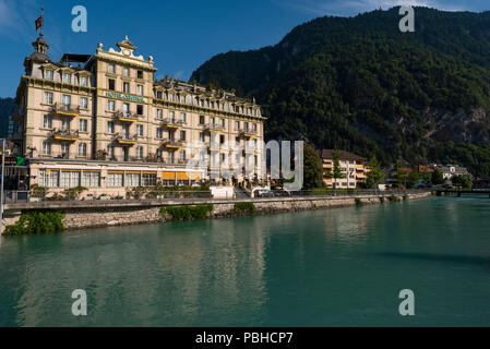 Hotel Central Continental in front of Aare River flowing through Interlaken city,Bernese Oberland region, Switzerland Stock Photo