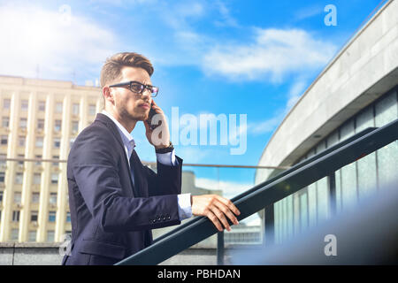 Handsome successful businessman in elegant suit outdoors walking on street in the city. Stock Photo
