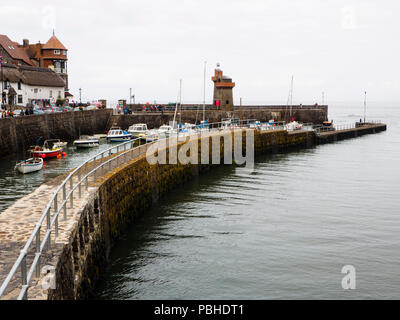 Curved sea wall at Lynmouth, Devon, UK, protects the fishing and pleasure craft in the small harbour Stock Photo