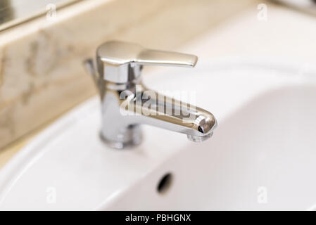 Classic modern white washbasins with chrome water tap Stock Photo