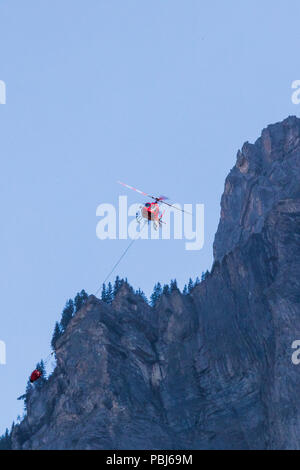 Fire helicopter with water tank in the air near kandersteg switzerland Stock Photo