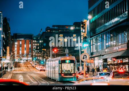 Helsinki, Finland. Tram Departs From A Stop On Kaivokatu Street In Helsinki. Night View Of Kaivokatu Street In Kluuvi District In Evening Or Night Ill