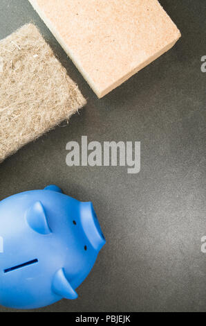 terracotta piggy bank and wall insulation panel on a stone background - top view Stock Photo