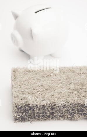 terracotta piggy bank and wall insulation panel on a white background - energy saving concept Stock Photo