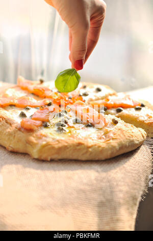 Pizza with salmon and basil and capers. Traditional Italian pastries. Copy space Stock Photo