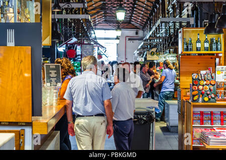 MADRID, SPAIN - AUGUST 27, 2017: People visiting and enjoying drinks and tapas inside the historical 'Mercado de San Miguel' (Market of San Miguel) Stock Photo