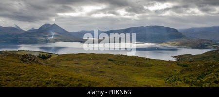 A fishing boat passes through Loch Torridon, an inlet of the Atlantic Ocean, under Ben Shieldaig and other mountains of the northwest Highlands of Sco Stock Photo