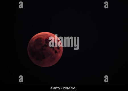 This photo shows the total eclipse of the moon at July 27th, 2018. The picture was taken near Stuttgart, Germany. Because of the reddish color of the moon, it is called blood moon. Stock Photo