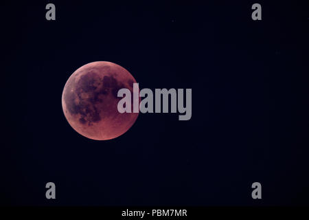 This photo shows the total eclipse of the moon at July 27th, 2018. The picture was taken near Stuttgart, Germany. Because of the reddish color of the moon, it is called blood moon. Stock Photo