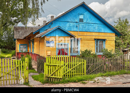 Vitebsk, Belarus - July 7, 2018: old wooden rural house with blue roof, surrounded by fence, stands in Belarusian village. Stock Photo