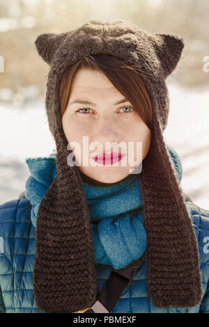 Portrait of stylish woman wearing funny winter knitted like cat ears hat Stock Photo