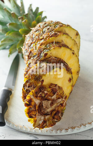 Fresh sliced pineapple on a white wooden cutting board. Top view Stock Photo