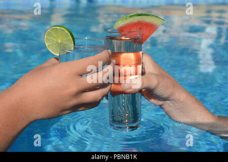 Cheers!  Enjoying a refreshing cocktail in the swimming pool Stock Photo