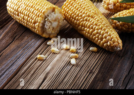 Fresh corn on cobs on rustic wooden table Stock Photo