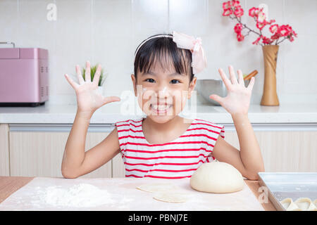 Asian Chinese little girl making dumpling in the kitchen at home Stock Photo