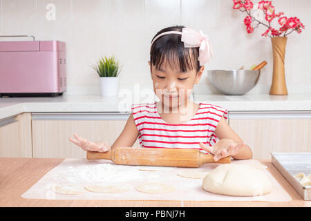 Asian Chinese little girl making dumpling in the kitchen at home Stock Photo