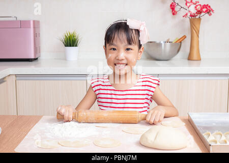 Asian Chinese little girl making dumpling in the kitchen at home Stock Photo