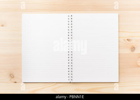Design concept - Top view of black kraft spiral notebook on wood table background for mockup Stock Photo