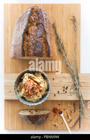 Hummus with wholemeal sourdough bread, paprika and lemon. Stock Photo