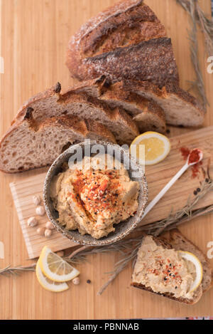 Hummus with wholemeal sourdough bread, paprika and lemon Stock Photo