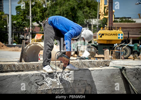 Thailand construction worker, builder drilling concrete wall Stock Photo