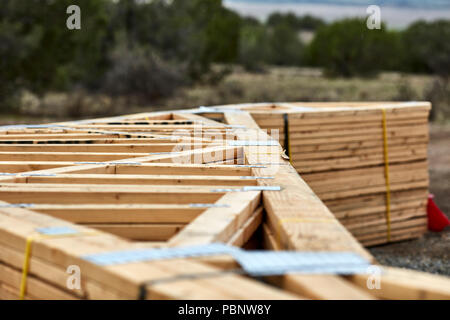 A large stack of roofing trusses laying on the ground Stock Photo