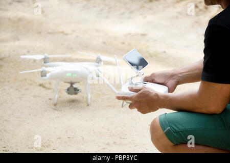 man playing drone holding remote control in hand Stock Photo
